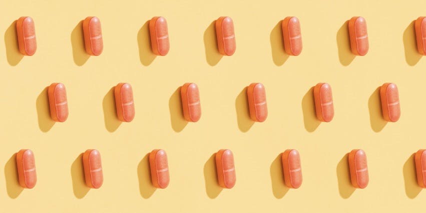 Un patrón repetitivo de pastillas anaranjadas sobre un fondo amarillo limón