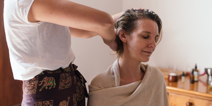 Relaxed woman receiving a traditional 'abhyanga' ayurvedic massage. Moment of head and scalp treatment.
