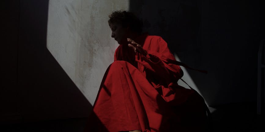 Mujer vestida de rojo moviéndose de rojo a la luz del sol.