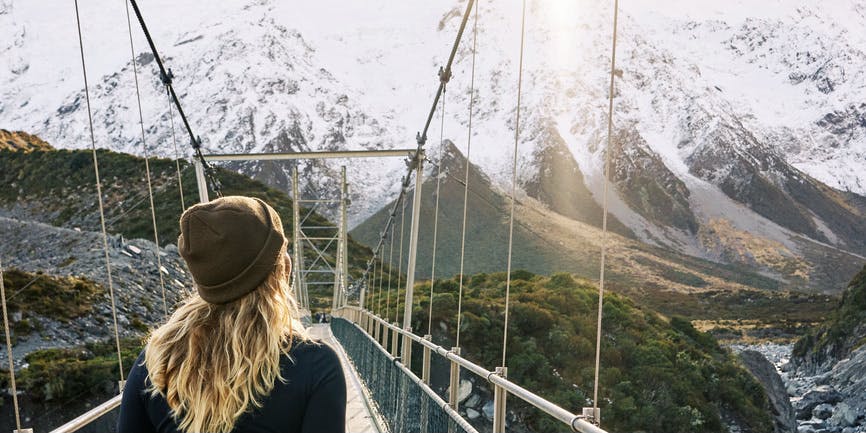 Mujer inspirada que disfruta de una caminata durante unas vacaciones de invierno en las montañas de Nueva Zelanda.