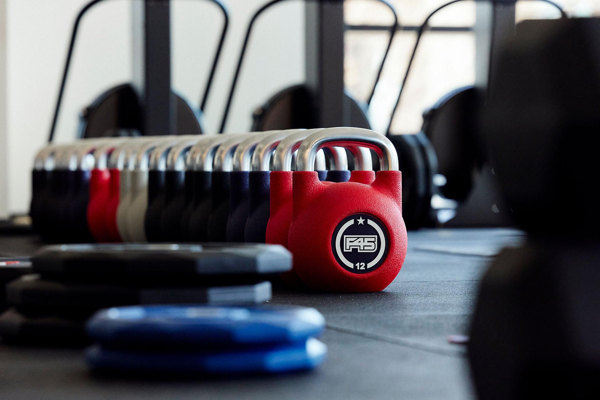 F45 Training weights lined up in a row on the floor of a gym