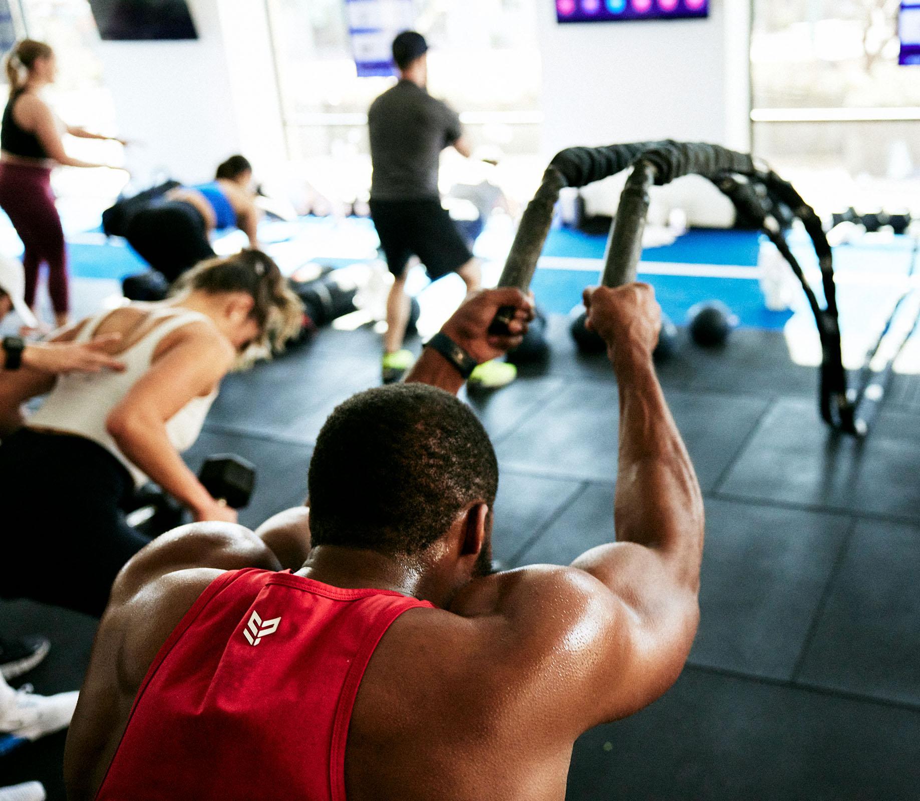 Man at F45 Training gym working with heavy ropes