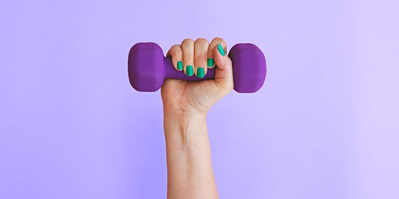 A hand with painted fingernails holding a small dumbell weight