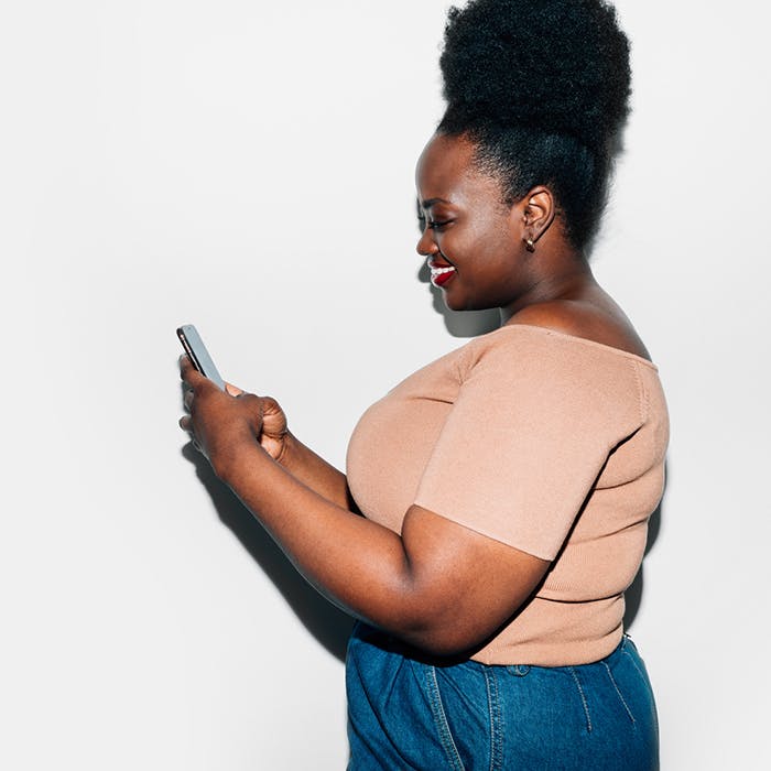 Plus-sized woman smiling while on phone