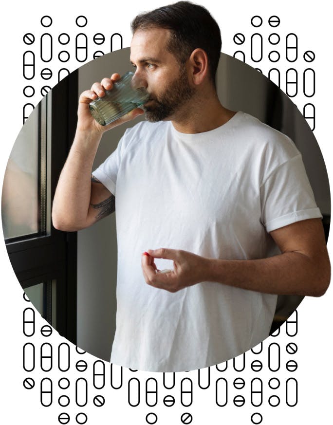 Man drinking water, about to take a pill